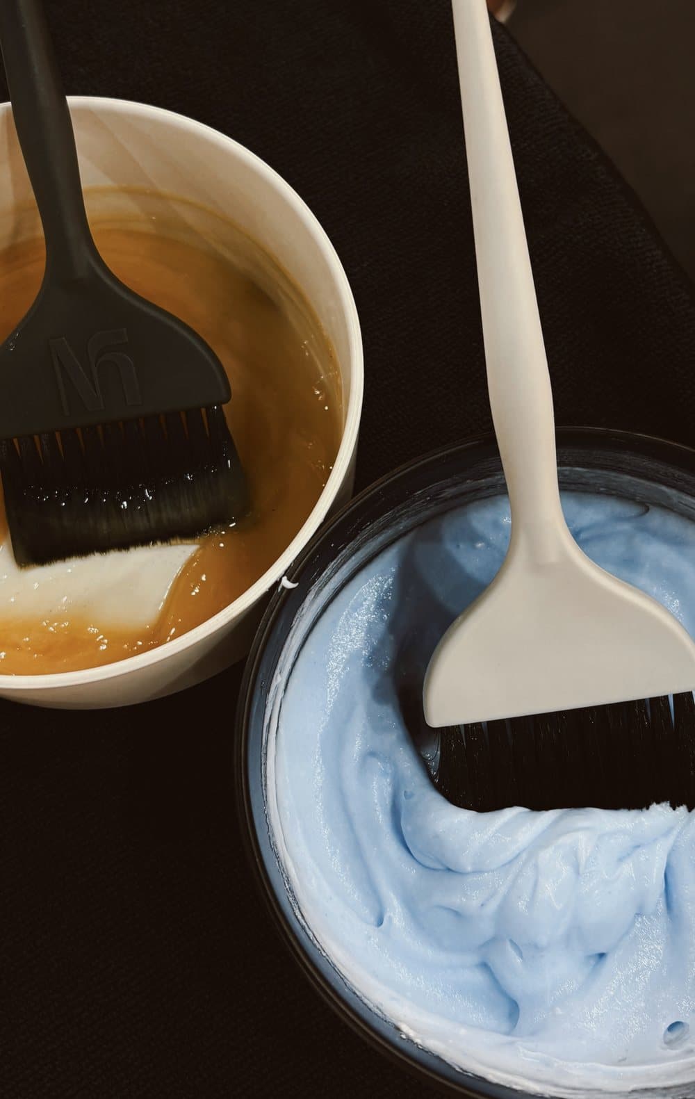 Two bowls of freshly mixed color with tint brushes