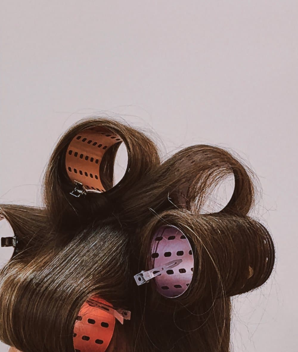 Brunette hair set in rollers, close detail of the styling process